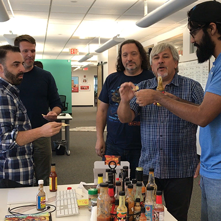 The gang toasts their chips to the latest hot sauce challenge.