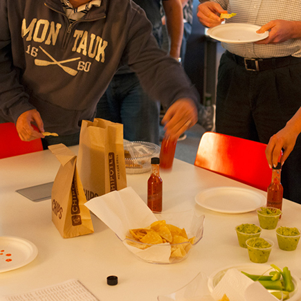 A spread of chips, guac, and hot sauce are set up for tasting.