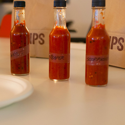 Four bottles of hot sauce are lined up for taste testing.